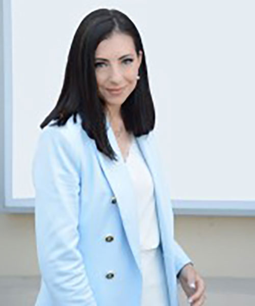Photo of Vaida A, a dark haired woman in a light blue jacket