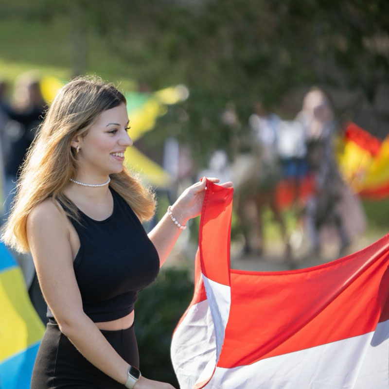 Eine ASSIST Scholar trägt ihre Landesflagge. Sie kommt aus Österreich.