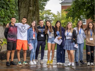 high school boys and girls from bulgaria smiling in front of trees on a new england boarding school campus