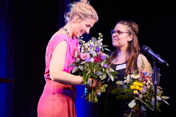 Eine ASSIST Scholar ist Opernsängerin. Sie bekommt gerade einen Blumenstrauß überreicht.